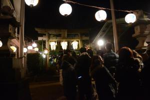 写真：新倉氷川八幡神社の鳥居とちょうちんと参拝者の列