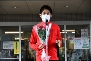 写真：花束とメダルを持って挨拶する川内優輝さん