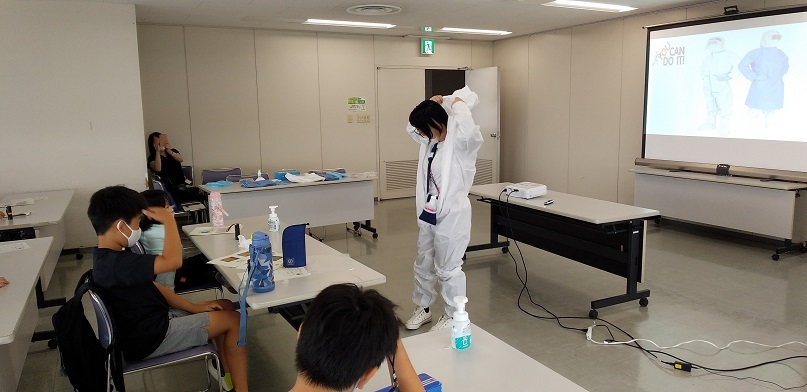 写真：防護服を着る講師