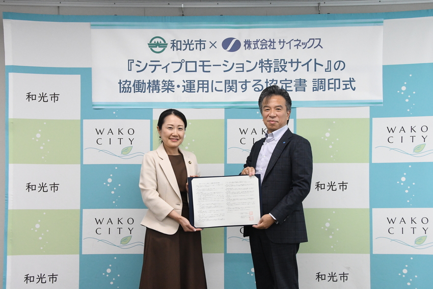 協定調印式で協定書を持った写真